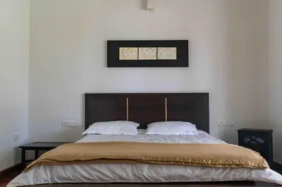 a bedroom with a large bed with two pillows at StayVista at The Lilly Ooty with Breakfast in Ooty