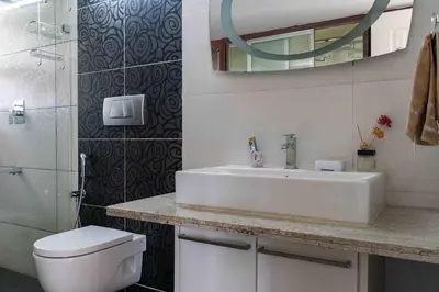 a bathroom with a sink and a toilet and a mirror at StayVista at The Lilly Ooty with Breakfast in Ooty