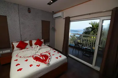 a bedroom with a bed with a heart pillow and a balcony at Bonita Banasura in Vythiri