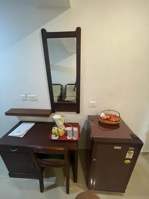 a bathroom with a vanity with a mirror on it at Kallada Sangeetha Hotels in Trichūr