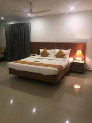 a bedroom with a large bed in a room at Kallada Sangeetha Hotels in Trichūr