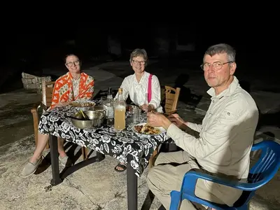 a group of people sitting at a table eating food at Woodside Homestay Wayanad in Batheri
