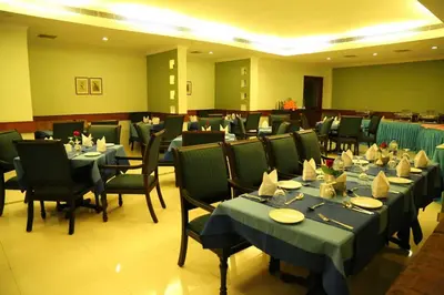 a dining room with tables and chairs and ythonythonython at Kallada hotels in Trichūr