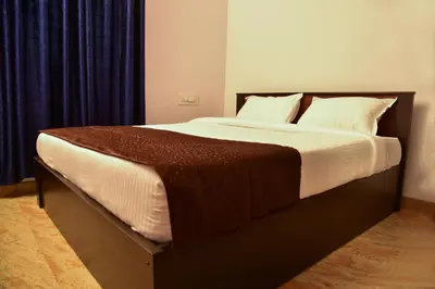 a bedroom with a large bed with blue curtains at Elegant Serviced Apartment in Mysore