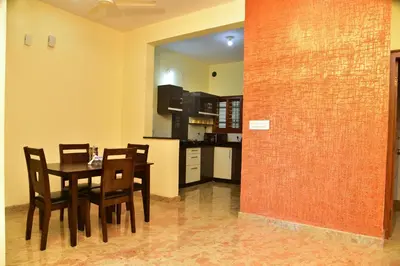 a kitchen and dining room with a table and chairs at Elegant Serviced Apartment in Mysore