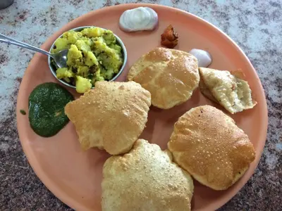 a plate of food with biscuits and a bowl of eggs at Elegant Serviced Apartment in Mysore