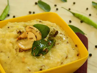 a yellow bowl of mashed potatoes with mushrooms and basil at Elegant Serviced Apartment in Mysore