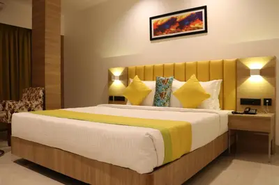 a hotel room with a large bed with yellow pillows at Hotel Park Residency Thrissur in Trichūr
