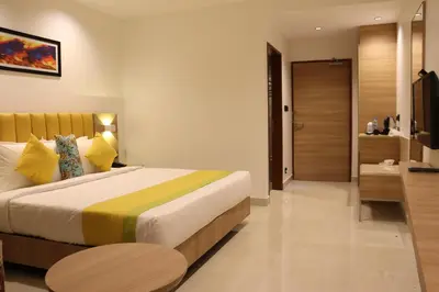 a bedroom with a large bed with a yellow and green blanket at Hotel Park Residency Thrissur in Trichūr