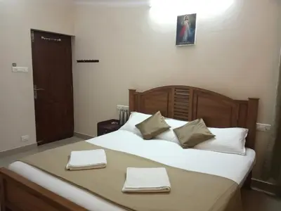 a bedroom with a bed with two towels on it at Ocean Stay in Nedumbassery
