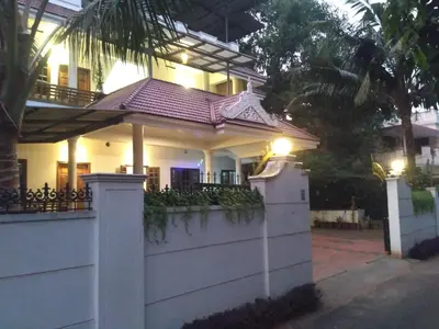 a white house with a fence in front of it at Ocean Stay in Nedumbassery