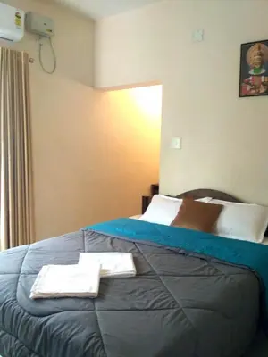 a hotel room with a bed with two towels on it at Ocean Stay in Nedumbassery
