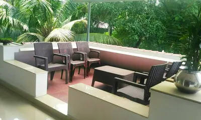 a group of chairs and tables on a patio at Ocean Stay in Nedumbassery