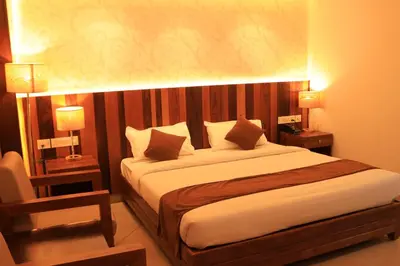 a bedroom with a large bed with two night stands at Lalys Residency in Trichūr