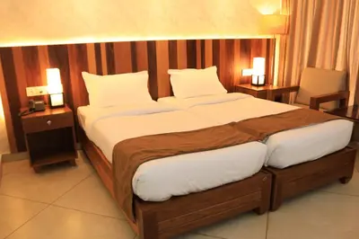 a large bed in a hotel room with two lamps at Lalys Residency in Trichūr