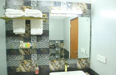 a bathroom with a sink and a mirror and towels at Lalys Residency in Trichūr