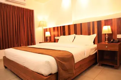 a bedroom with a large bed with a wooden headboard at Lalys Residency in Trichūr