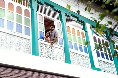 a man and a woman looking out of the window of a house at Villa De 1945 in Mahe