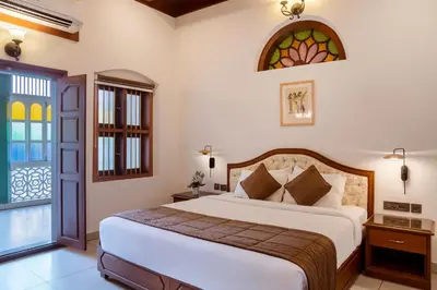 a bedroom with a bed and a stained glass window at Villa De 1945 in Mahe