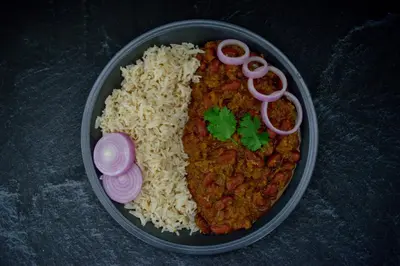 a bowl of food with rice and meat and onions at Super Townhouse Srm Kuppakonam Pudur in Coimbatore