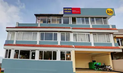 a building with a motorcycle parked in front of it at Itsy Hotels Rain Forest, 1 km from Rose Garden in Ooty
