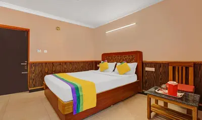 a bedroom with a large bed with a colorful blanket at Itsy Hotels Rain Forest, 1 km from Rose Garden in Ooty