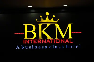 a logo for a business class hotel with a crown at Hotel BKM International in Tellicherry