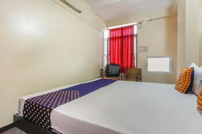 a bedroom with a large bed and a window at SPOT ON Thangam Lodge in Coimbatore