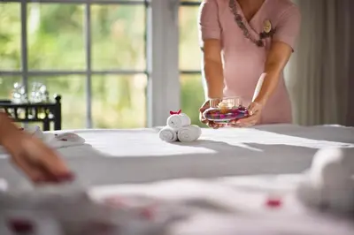 a woman standing at a table with a bowl of candy at Coorg Wilderness Resort & Spa in Madikeri