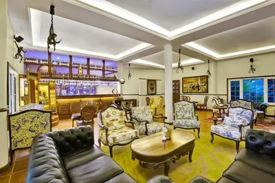a living room with couches and a bar at Coorg Wilderness Resort & Spa in Madikeri