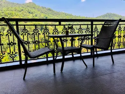 a table and two chairs sitting on top of a balcony at Coorg Wilderness Resort & Spa in Madikeri