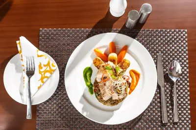 a plate of food with carrots on a table at The Sanihara Hotel & Resort in Vythiri