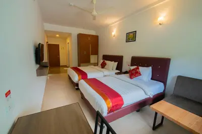 a hotel room with two beds and a table at The Sanihara Hotel & Resort in Vythiri