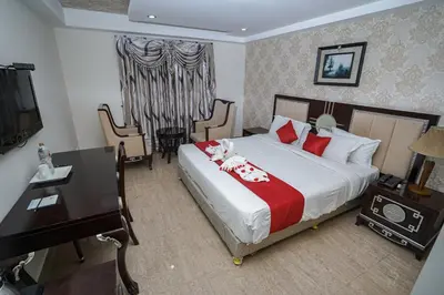 a bedroom with a bed and a desk and a television at Hotel Sidhartha Chalakudy in Kizhake Chālakudi
