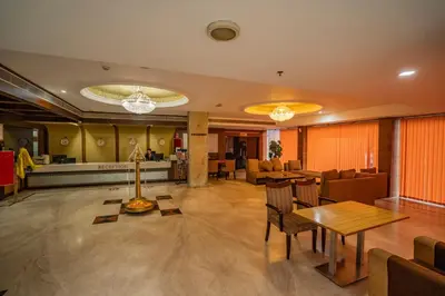 a lobby of a hotel with a table and chairs at Hotel Sidhartha Chalakudy in Kizhake Chālakudi