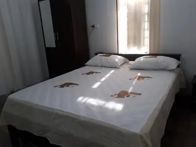 a bedroom with a bed with white sheets and a window at Family villa .hut in Tariyod