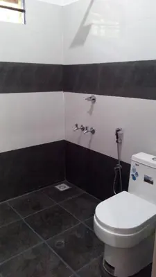 a bathroom with a toilet and black and white walls at Family villa .hut in Tariyod