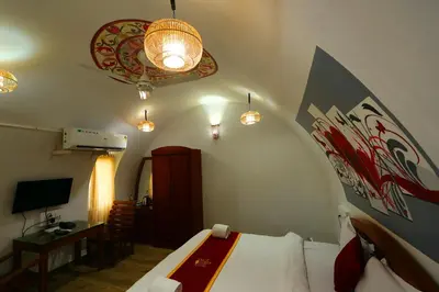 a bedroom with a bed and a desk and a lamp at Wayanad Cave N Pillar Resort in Sultan Bathery