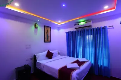 a bedroom with two beds in a room with purple lights at Wayanad Cave N Pillar Resort in Sultan Bathery