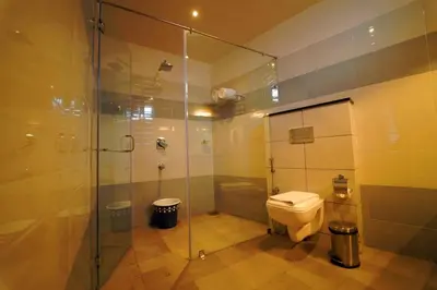 a bathroom with a toilet and a glass shower at WithInn Hotel - Kannur Airport in Kannur