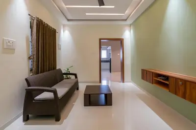 a living room with a couch and a coffee table at THE SURRYA MAX RESIDENCY in Pollāchi
