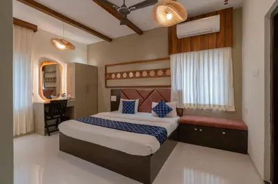a bedroom with a large bed and a desk at THE SURRYA MAX RESIDENCY in Pollāchi