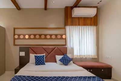 a bedroom with a bed with blue and white pillows at THE SURRYA MAX RESIDENCY in Pollāchi