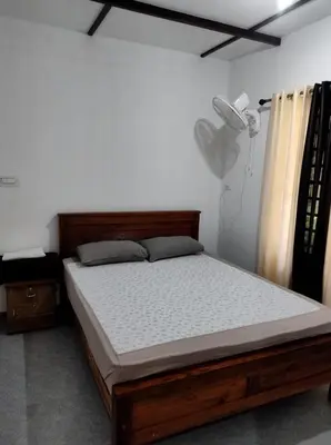 a bedroom with a bed and a lamp and curtains at Standard family hut in Tariyod
