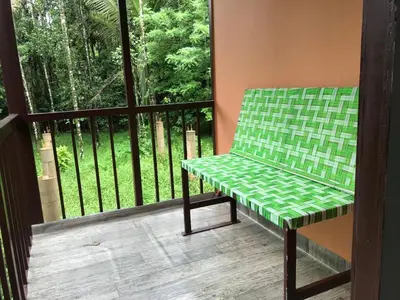 a green bench sitting on a balcony with a window at Standard family hut in Tariyod