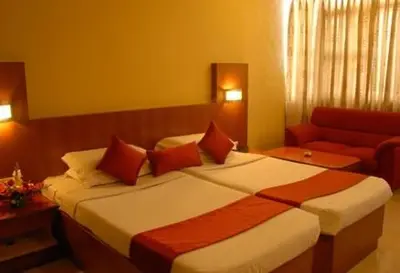 a hotel room with a bed and a couch at Hotel Maurya Palace in Mysore
