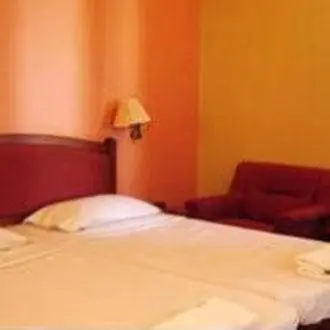 a bedroom with a white bed and a chair at Hotel Maurya Palace in Mysore