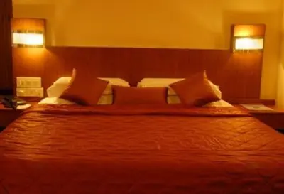 a bedroom with a large bed with pillows at Hotel Maurya Palace in Mysore