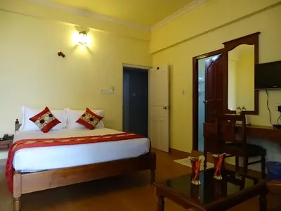 a bedroom with a bed and a table and a mirror at Sealine Beach Resorts in Cherai Beach