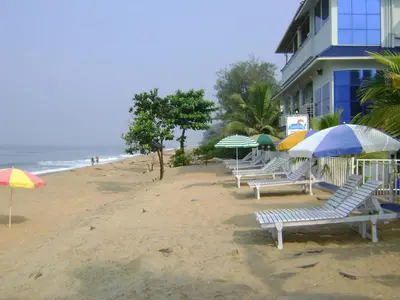 a row of chairs and umbrellas on a beach at Sealine Beach Resorts in Cherai Beach